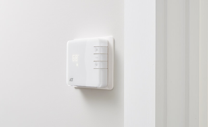 ADT Command Panel A wall-mounted ADT smart thermostat with simple controls and LED display for managing indoor climate.